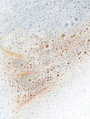 Close-up of Whisper Sensitive Shampoo soap bubbles on a white background